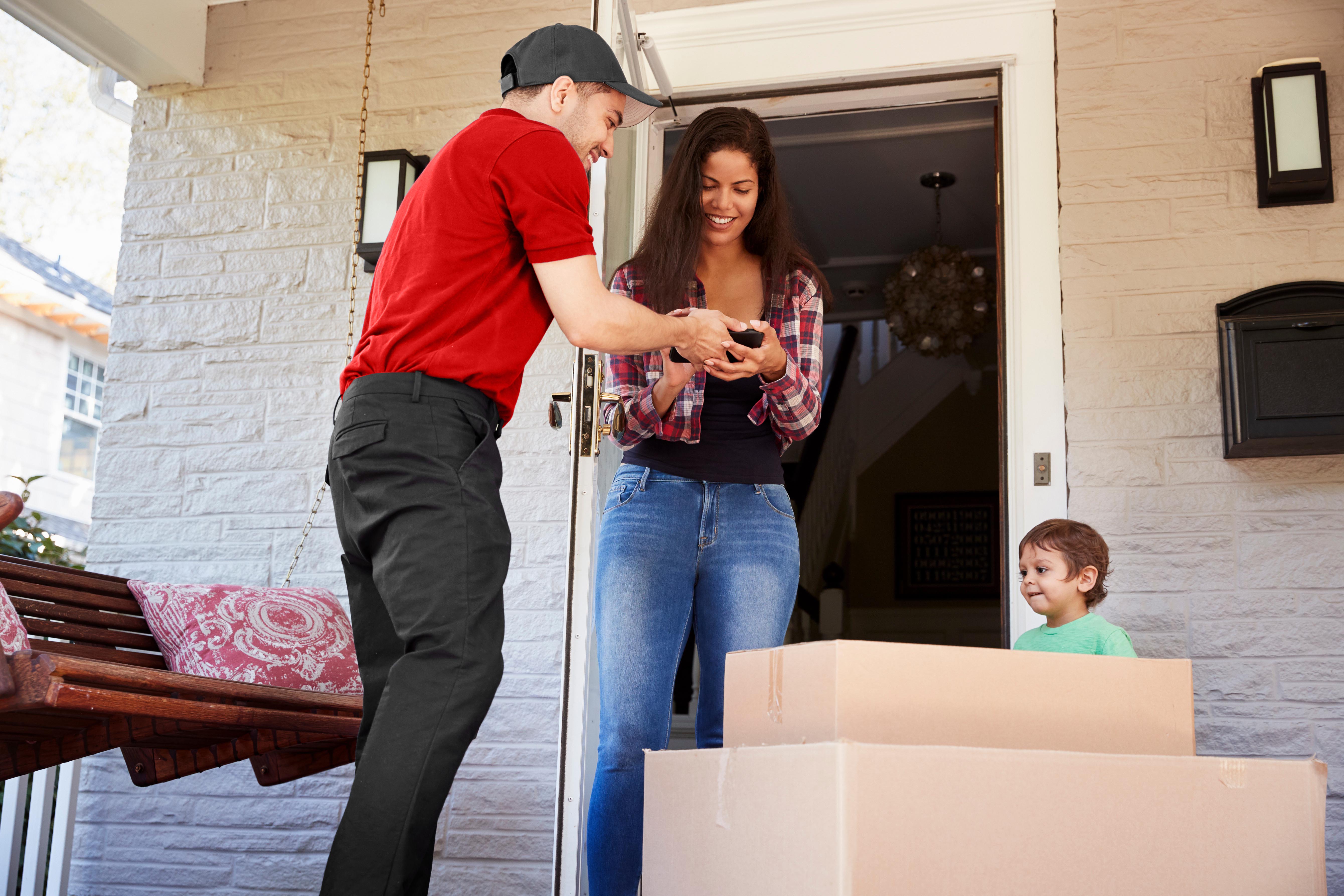Desert Moving mover handing tablet to smiling customer at door